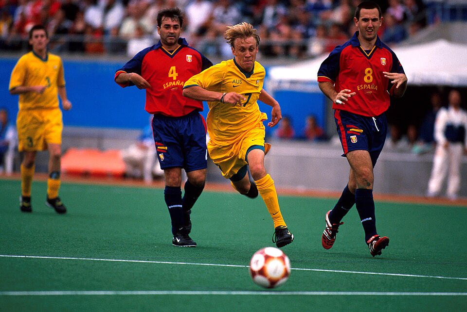 Vista aérea de un partido de fútbol con ambos equipos bien escalonados